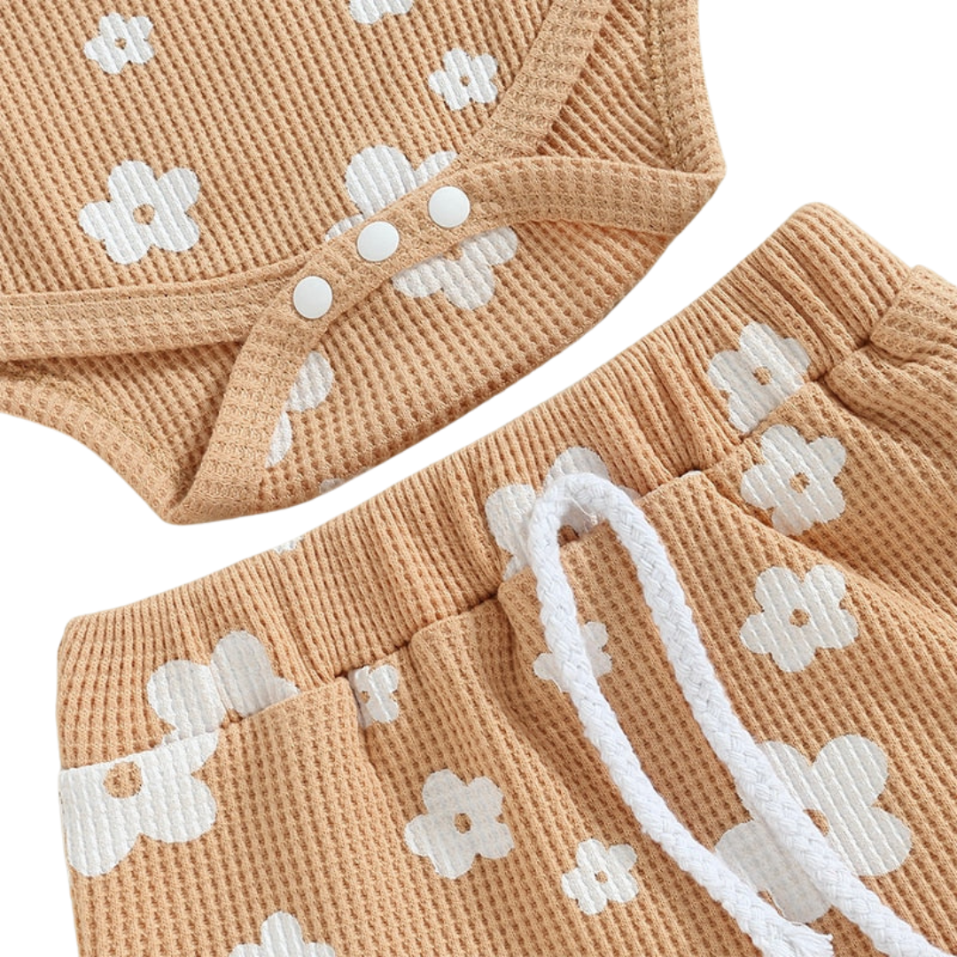 Daisy Romper and Bummies Set - Beige Baby outfit set including a white sleeveless bodysuit with pink floral pattern, matching shorts, and a bow headband