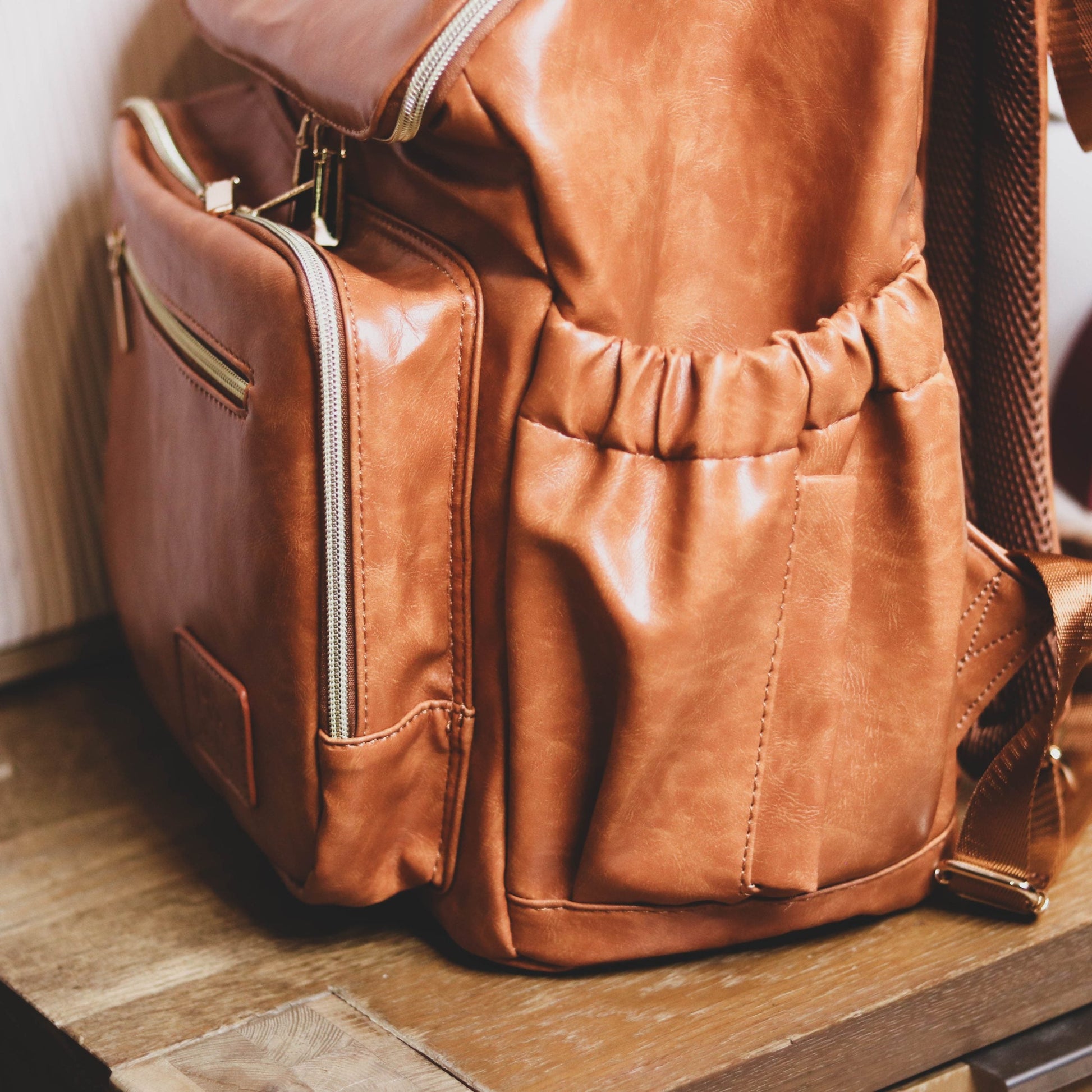 Faux Leather Nappy Bag Backpack - Luxe Tan Brown Our Faux Brown Leather Nappy Bag adds a sophisticated look to an everyday essential, stylish, functionality for everyday use. Nappy bag backpacks are an essential part of the babies haul when leaving the house – A Must have! An Amazing quality, so soft to touch, multi functional backpack, perfect for busy parents.