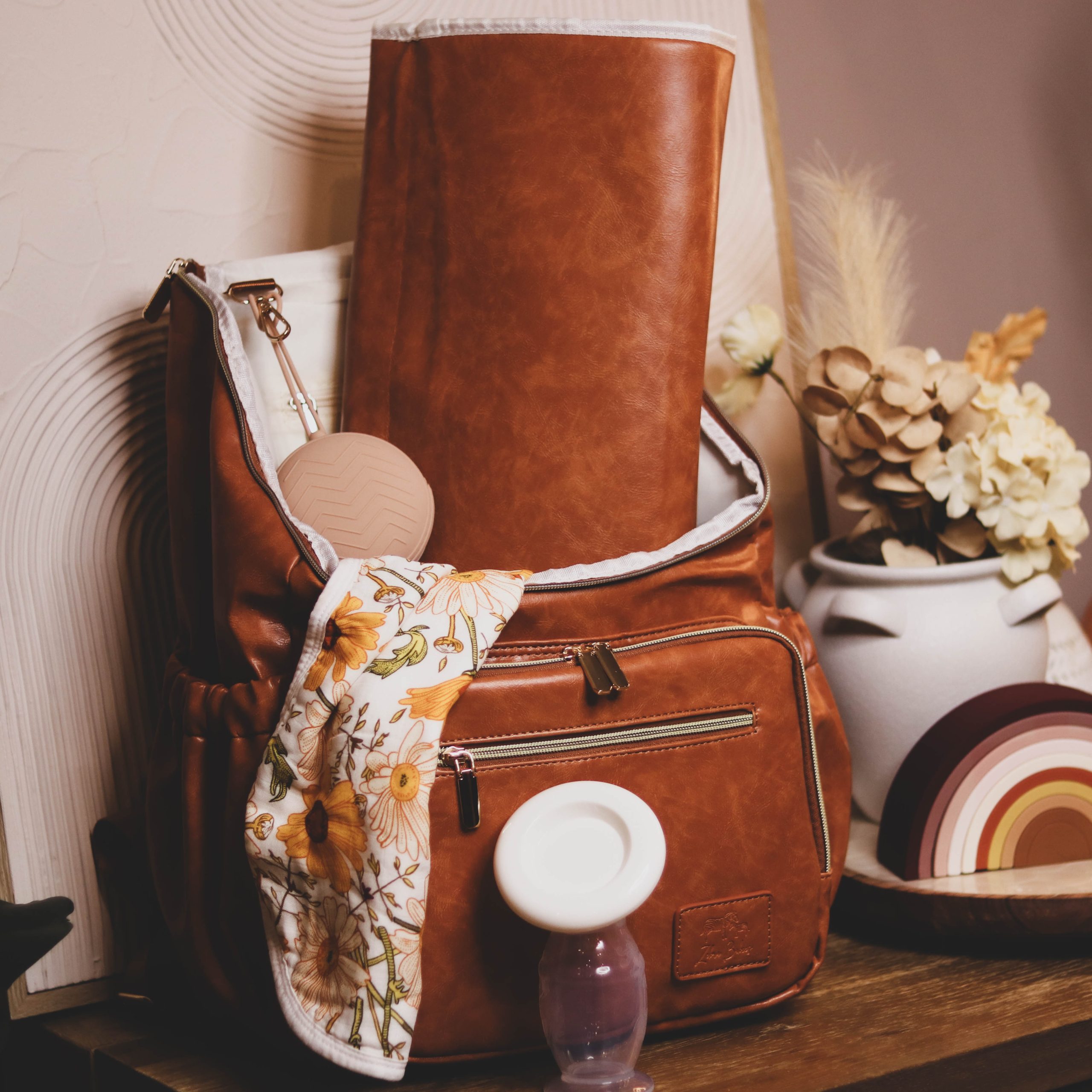 Faux Leather Nappy Bag Backpack - Luxe Tan Brown Our Faux Brown Leather Nappy Bag adds a sophisticated look to an everyday essential, stylish, functionality for everyday use. Nappy bag backpacks are an essential part of the babies haul when leaving the house – A Must have! An Amazing quality, so soft to touch, multi functional backpack, perfect for busy parents.